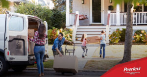 Family moving into a new home, caring boxes, with Peerless Cleaning & Restoration Services branding.